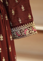 Maroon fabric with gold and pink embroidery on a neutral background