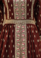 Maroon traditional outfit with intricate white and pink embroidery on a neutral background