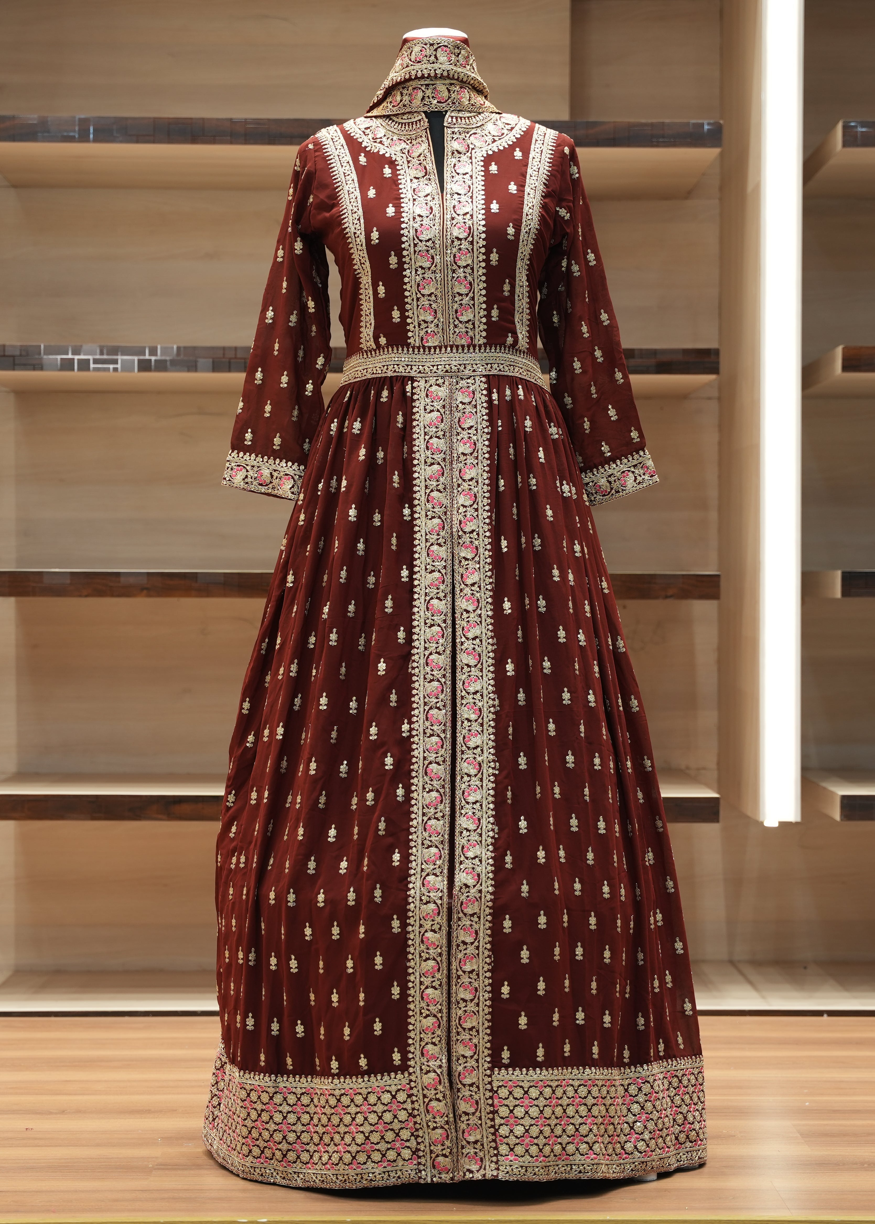 Decorative dress with intricate patterns on a mannequin against a neutral background