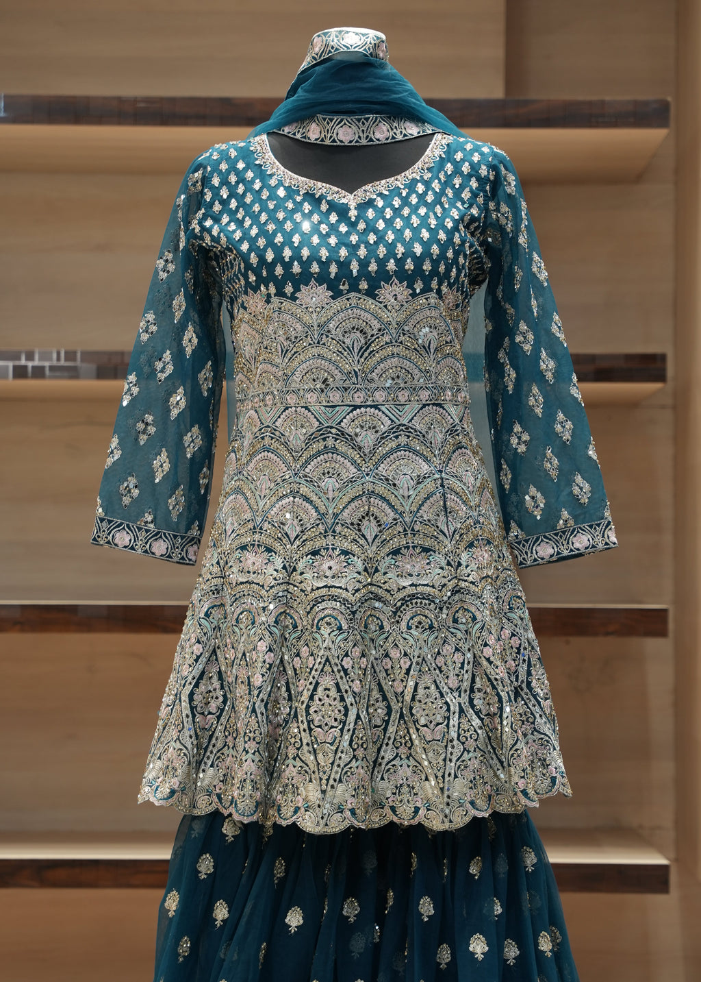 Traditional embroidered outfit on a mannequin against a neutral background