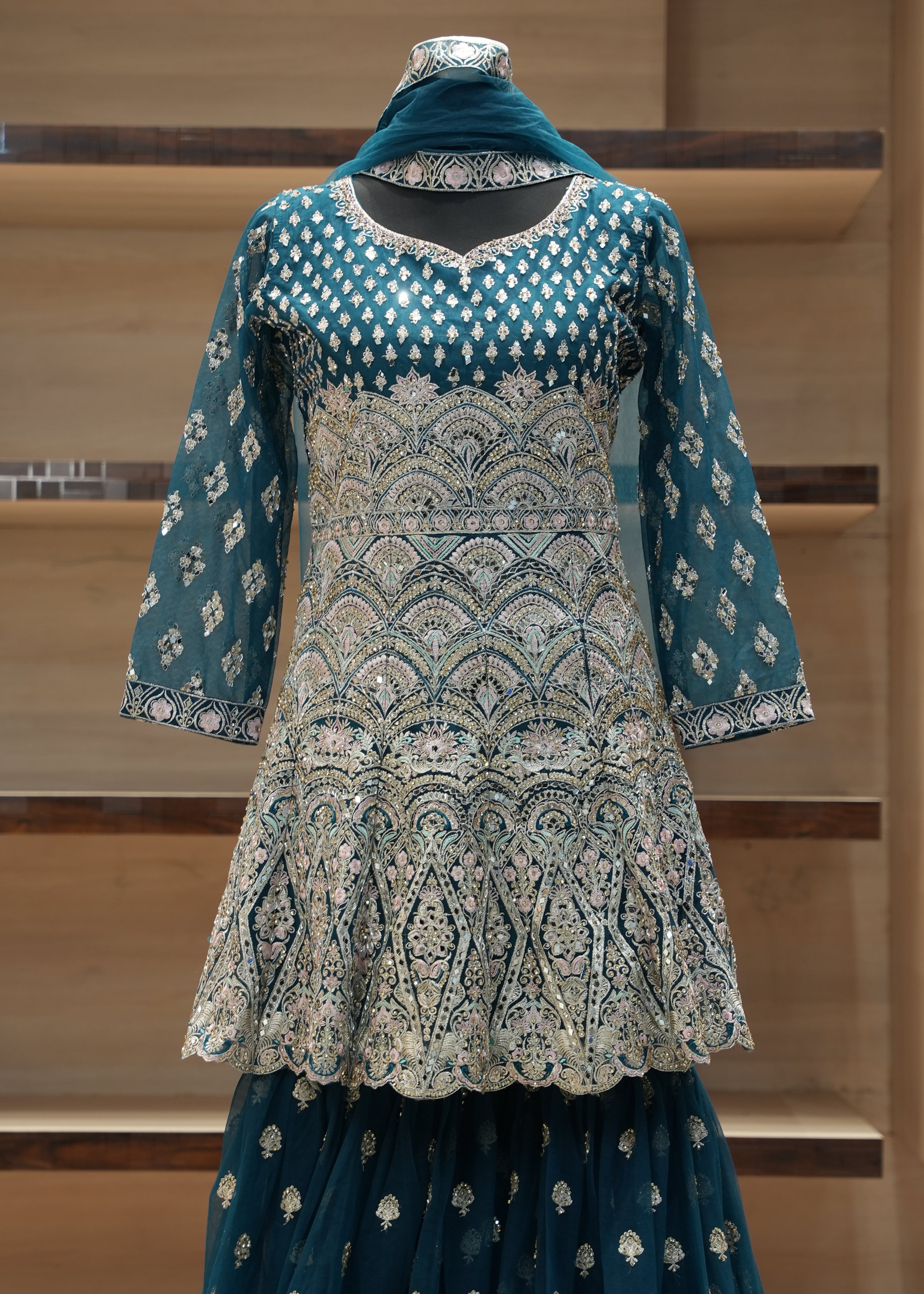 Traditional embroidered outfit on a mannequin against a neutral background