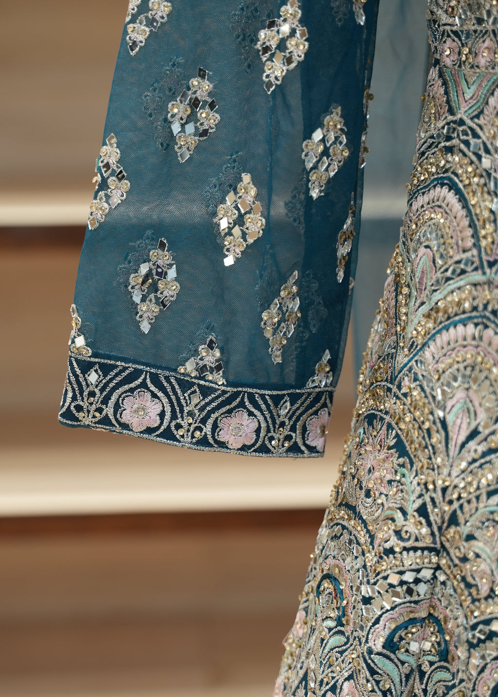 Close-up of a blue embroidered fabric with intricate patterns on a blurred background