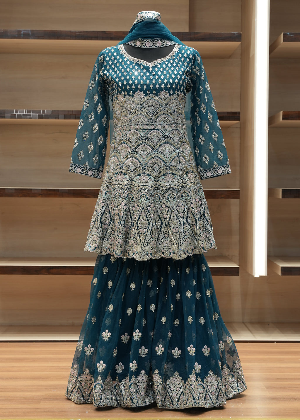 Traditional embroidered garment on a mannequin against a wooden background