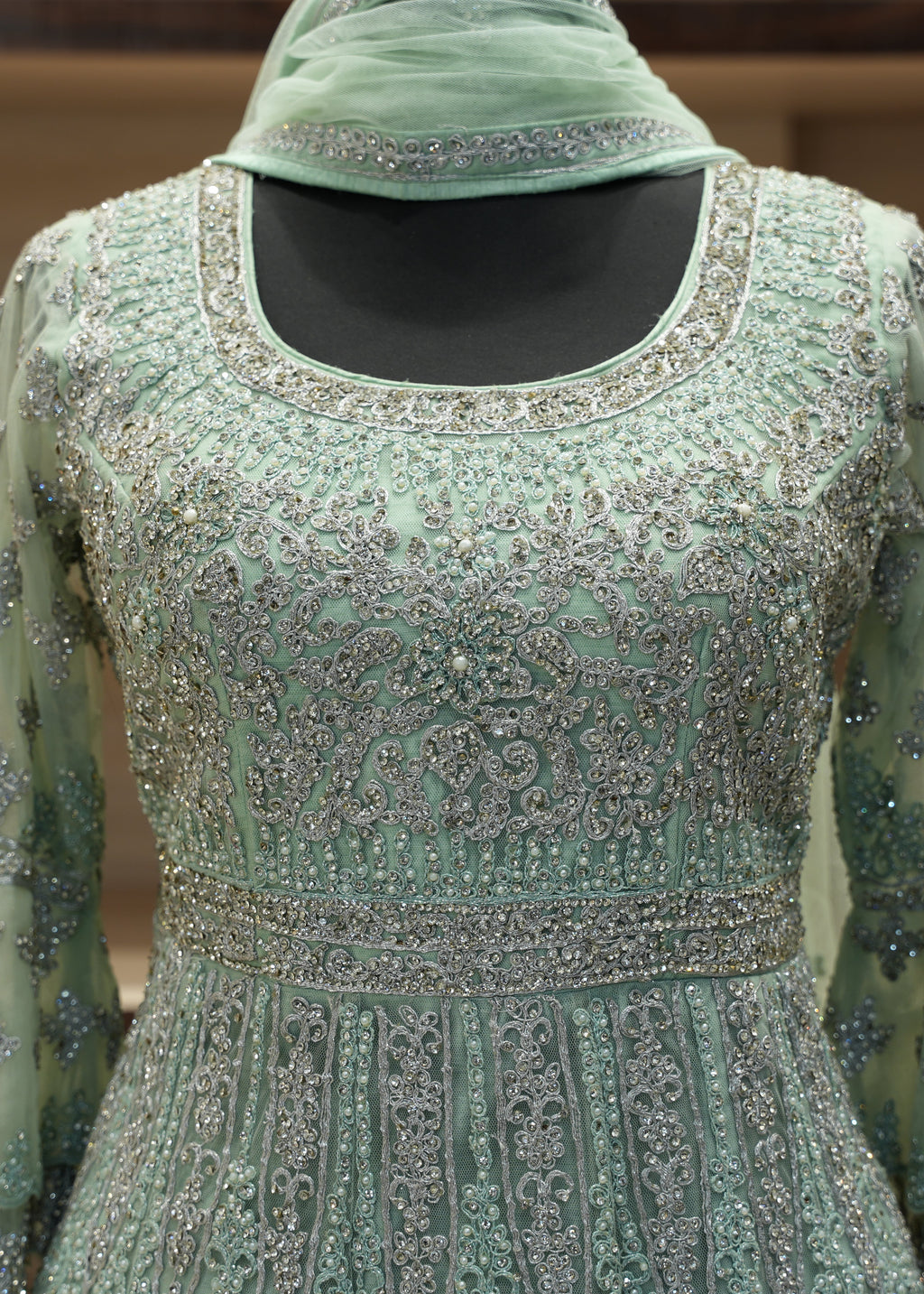 Mint green embroidered dress with a matching headscarf on a mannequin.