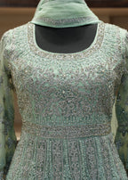 Mint green embroidered dress with a matching headscarf on a mannequin.