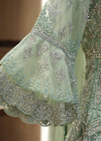 Close-up of a light green embroidered fabric with intricate patterns