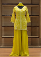 Yellow dress on a mannequin against a wooden background