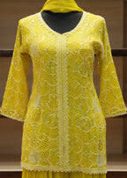 Yellow lace top on a wooden stand with a blurred background