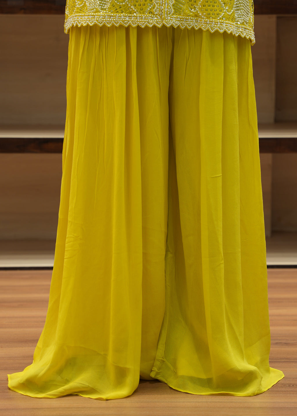 Yellow fabric with lace trim draped over a wooden surface