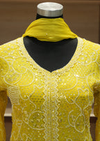Yellow embroidered garment on a mannequin with a blurred background