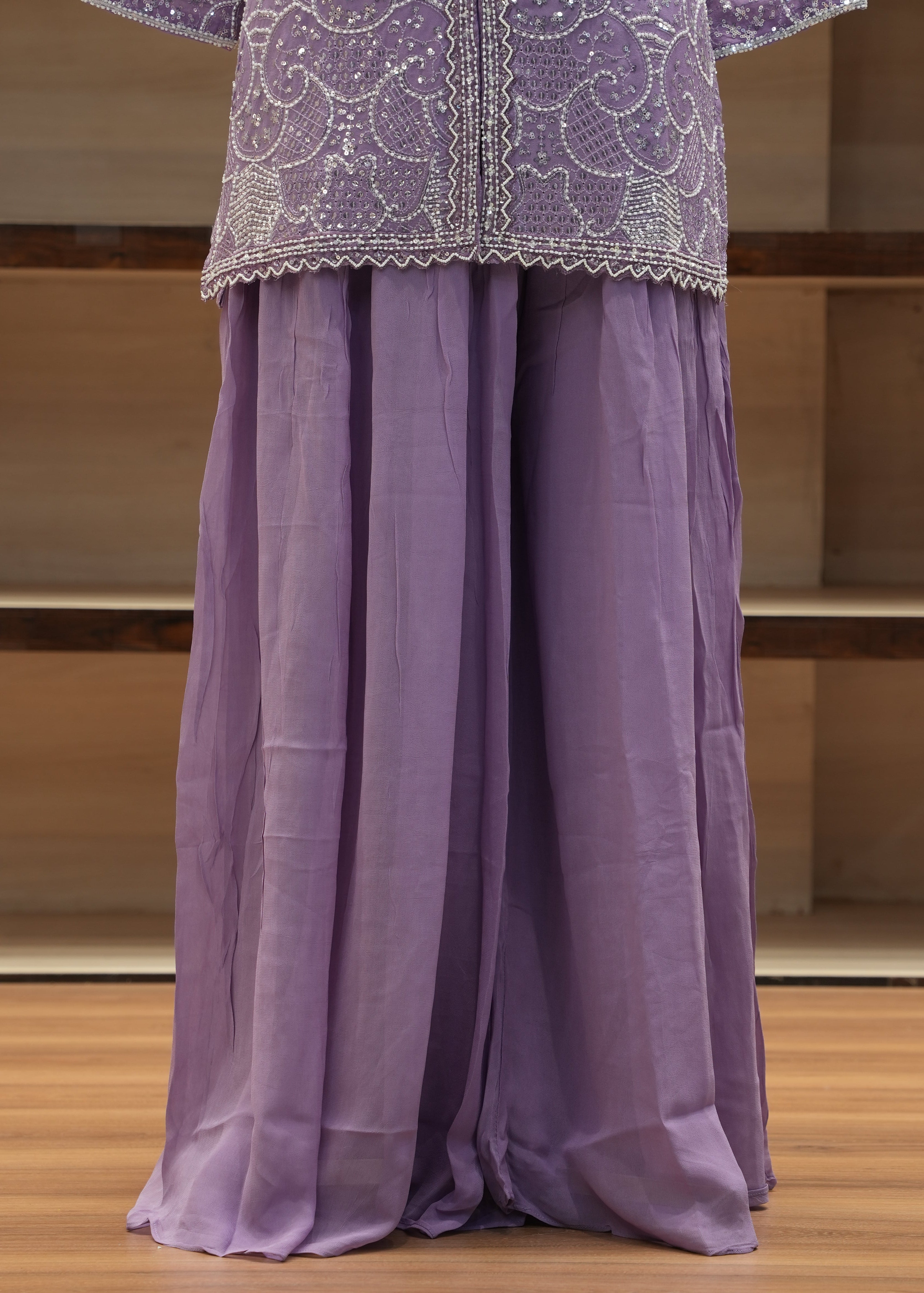 Folded purple fabric with lace trim on a wooden surface