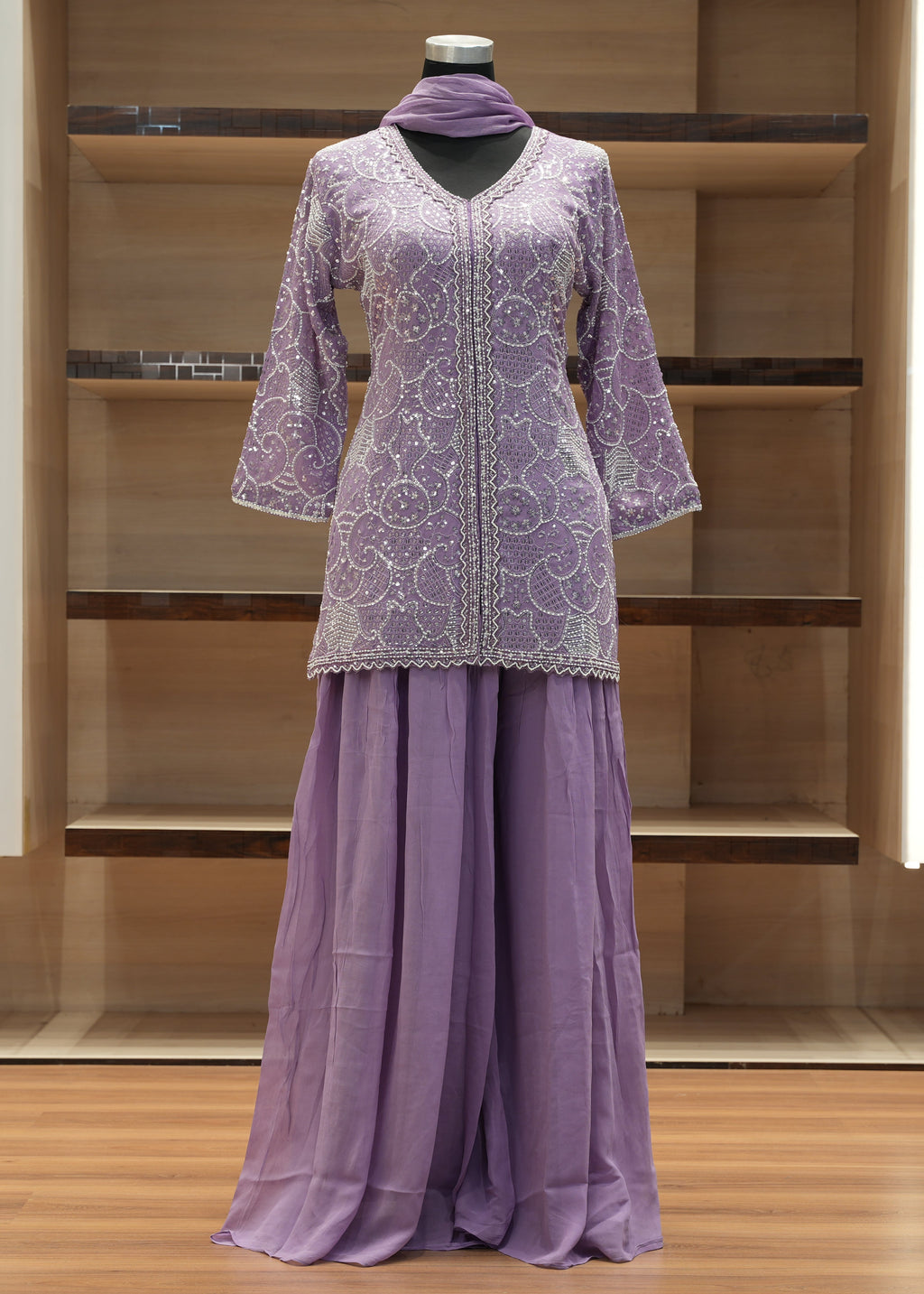 Purple outfit with lace top and flowing skirt on a mannequin against a wooden background