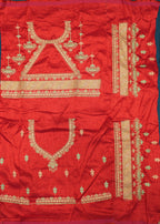 Red fabric with gold embroidery on a wooden surface