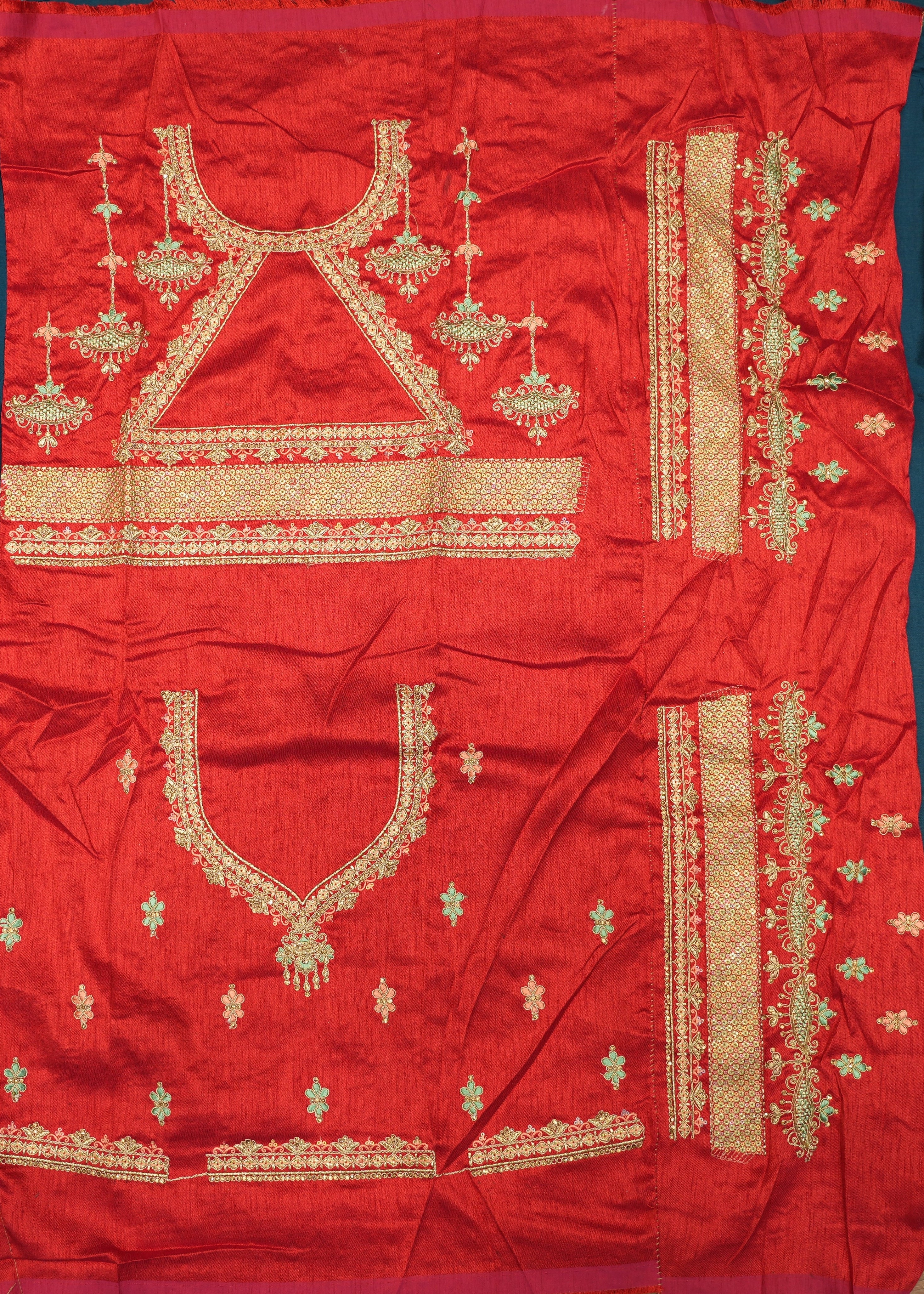 Red fabric with gold embroidery on a wooden surface