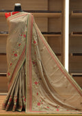 Beige saree with floral embroidery on a mannequin against a wooden shelf background