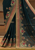 Dark green saree with intricate gold and red embroidery on a wooden surface