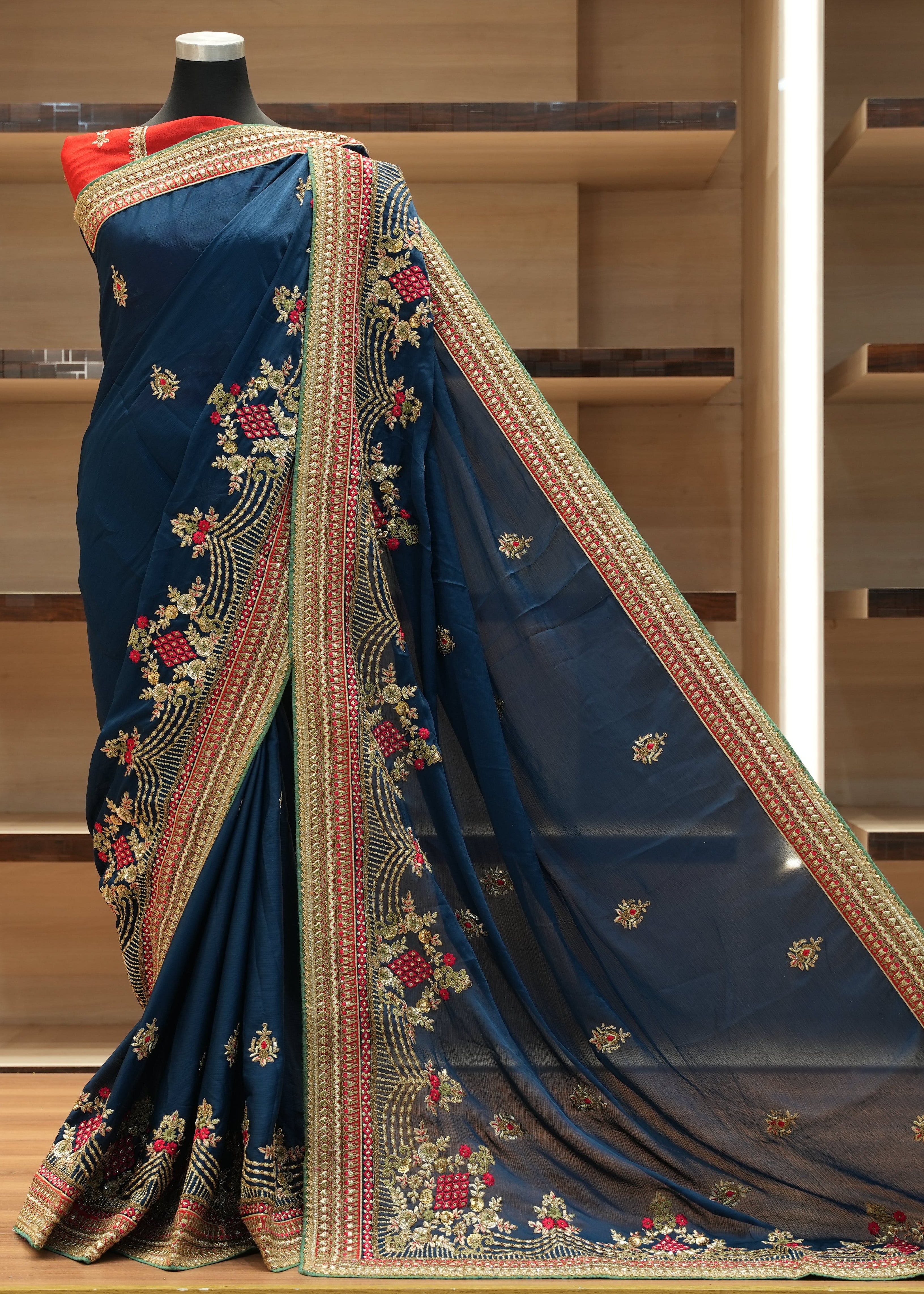 Blue saree with intricate patterns on a wooden shelf background