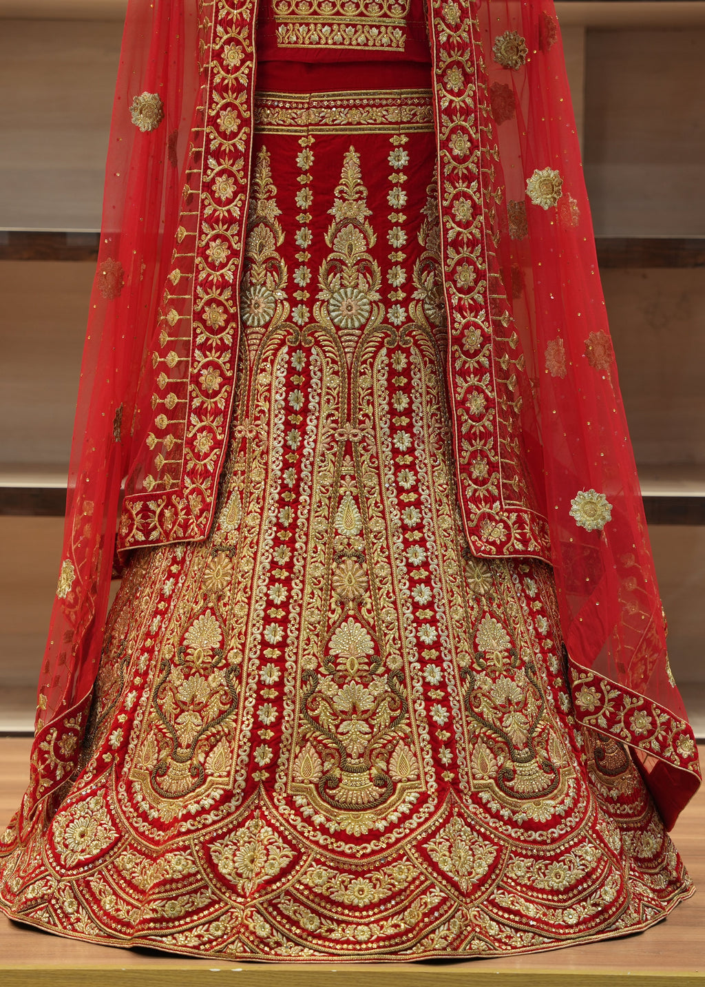 Red and gold embroidered traditional outfit on a wooden floor