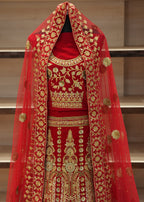 Red fabric with gold embroidery on a stand against a neutral background