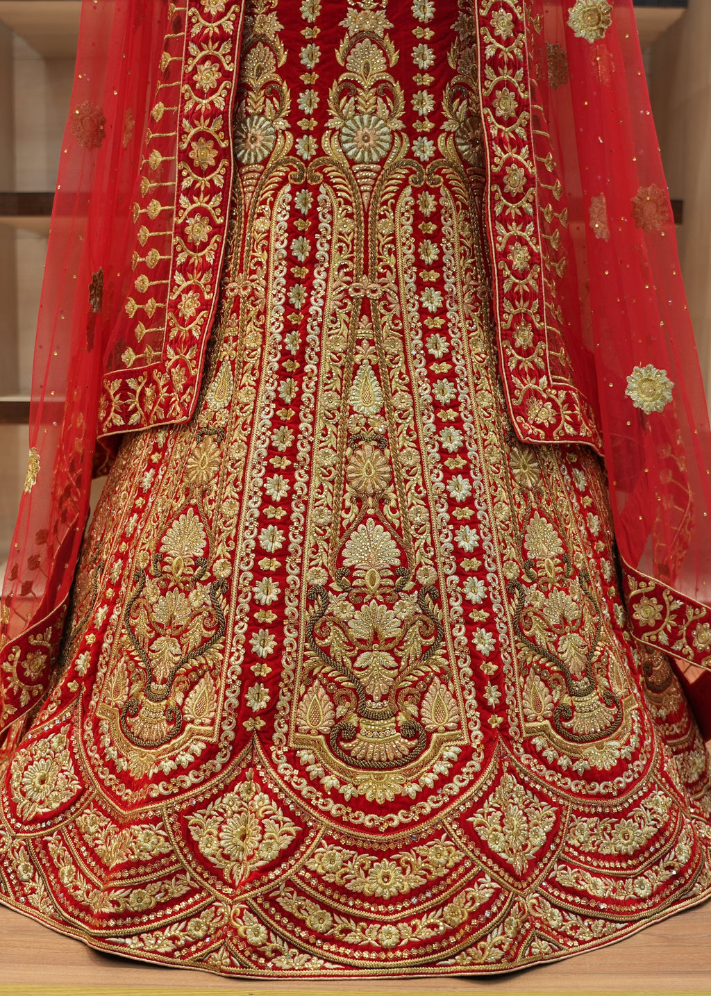 Red and gold embroidered traditional outfit on a wooden floor