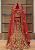 Red and gold embroidered traditional outfit on a wooden floor with shelves in the background