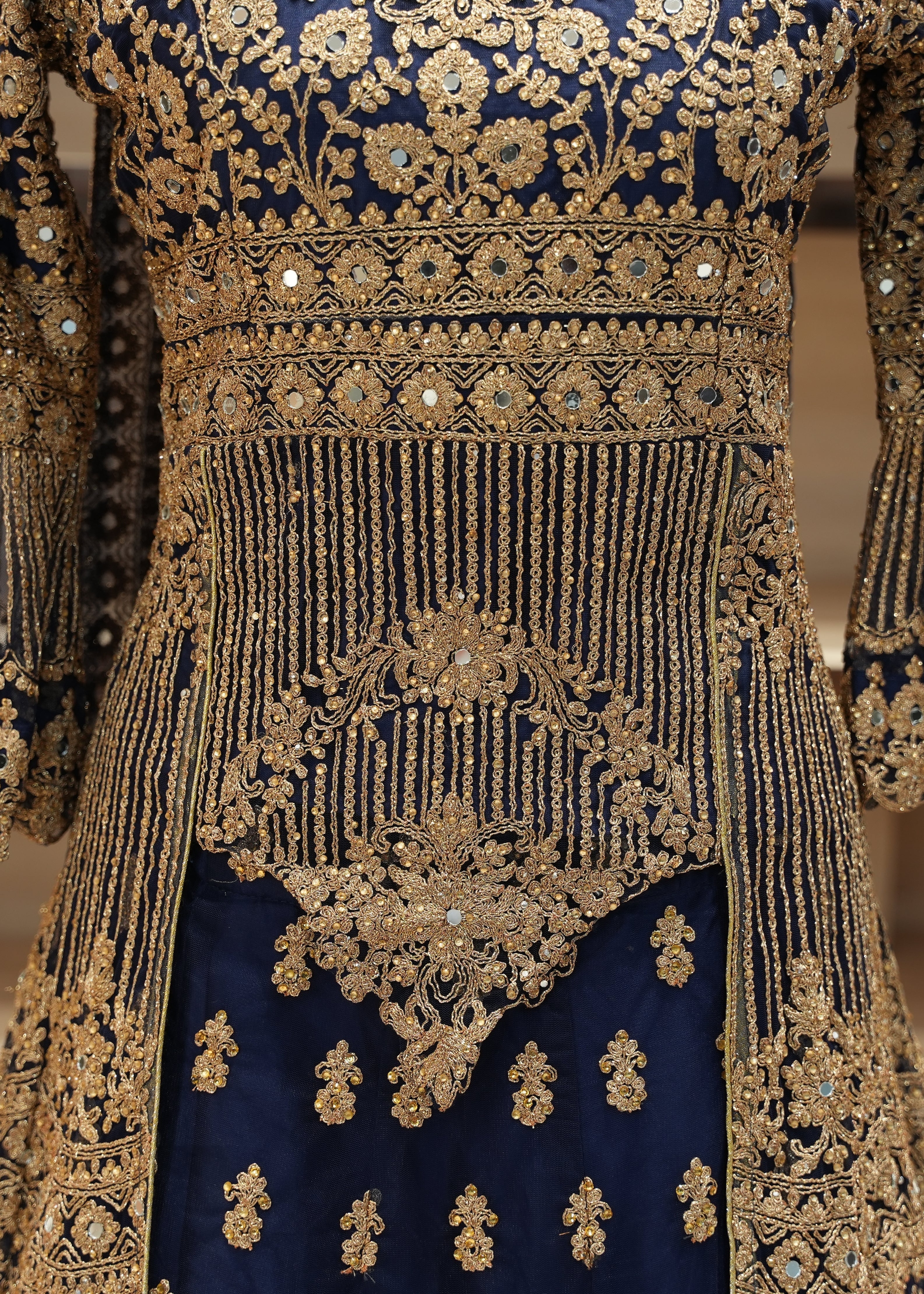 Decorative traditional outfit with intricate gold embroidery on a blue background
