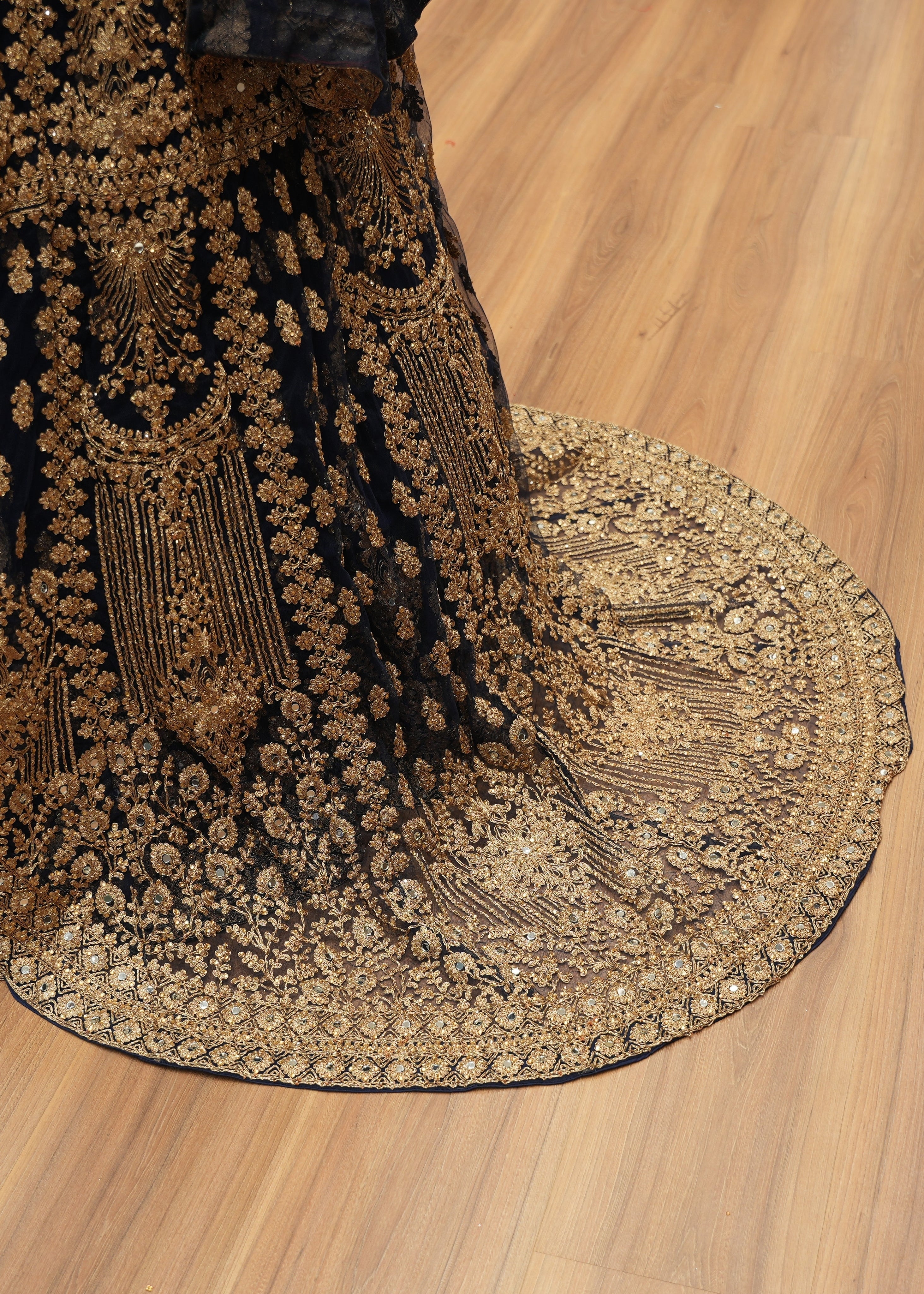 Decorative fabric with intricate gold patterns on a wooden floor