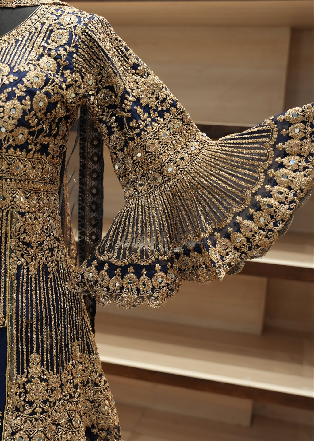 Navy blue and gold embroidered traditional outfit with intricate patterns.