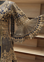 Navy blue and gold embroidered traditional outfit with intricate patterns.