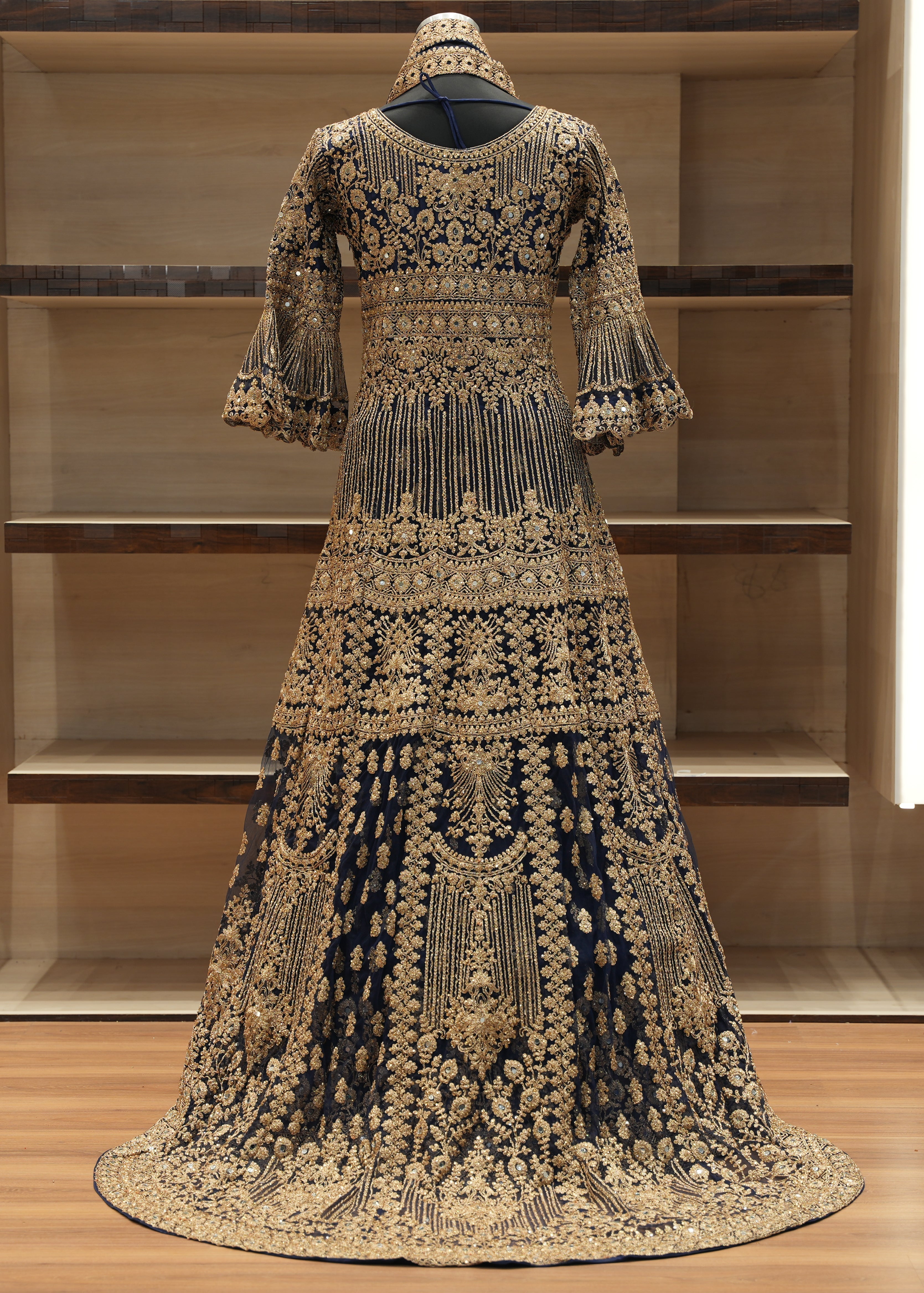 Elaborately designed dress with intricate patterns on a wooden floor.