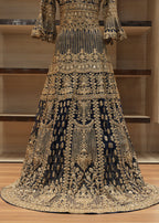 Elaborately embroidered traditional dress on a wooden floor with shelves in the background