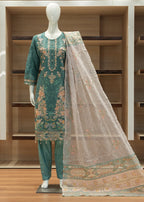 Teal embroidered fabric on a mannequin with a sheer fabric draped over it against a wooden background
