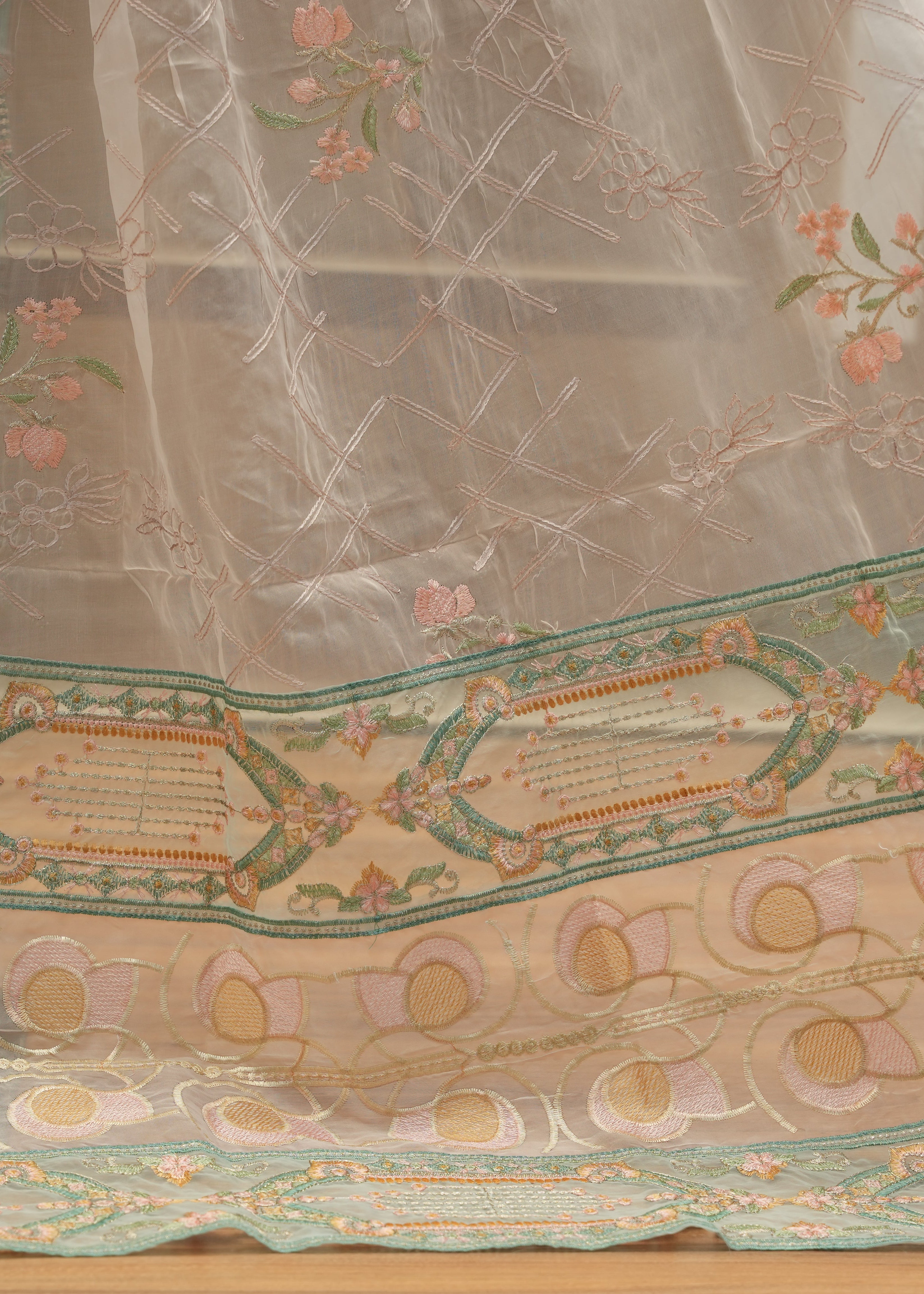 Embroidered fabric with floral and geometric patterns on a wooden surface