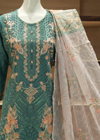 Green embroidered outfit with a sheer dupatta on a mannequin against a neutral background