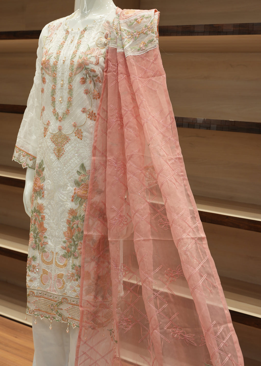 Floral dress with pink overlay on a wooden surface