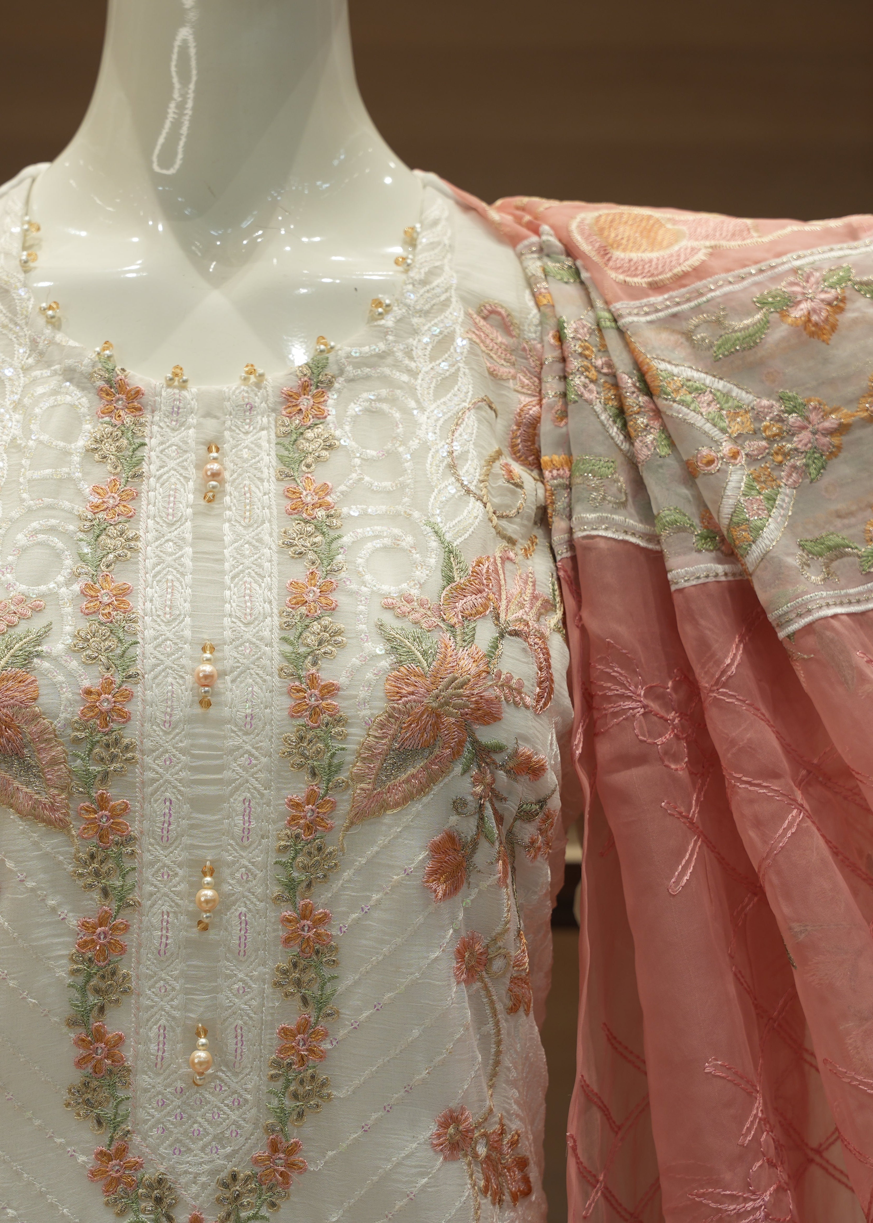 Embroidered traditional outfit with floral patterns on a mannequin.