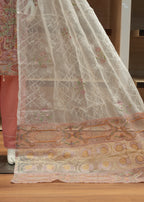 Decorative fabric with intricate patterns draped over a wooden surface.