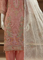 Embroidered pink and white traditional outfit on a mannequin with a neutral background