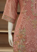 Mannequin wearing a pink embroidered dress with intricate patterns.