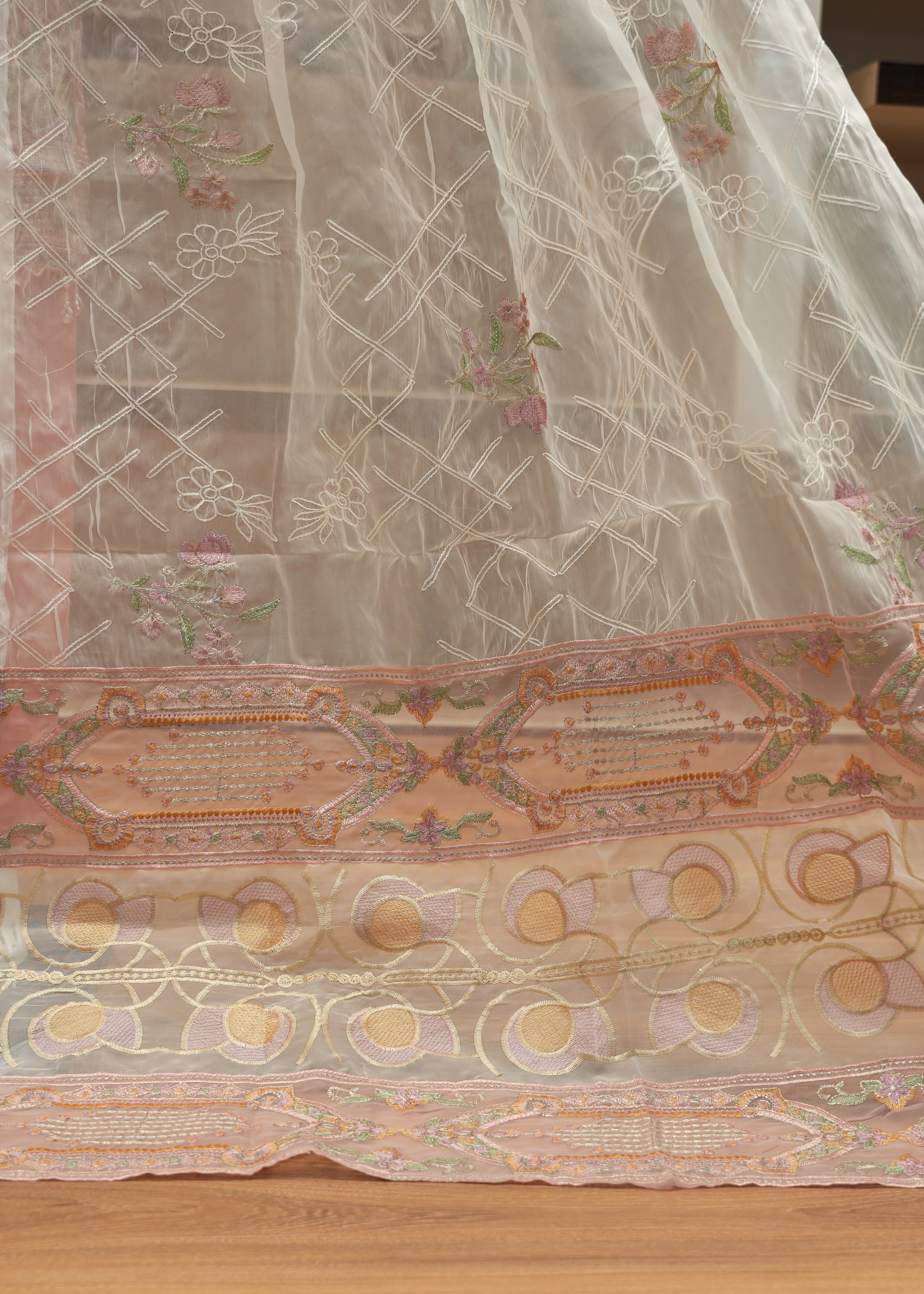 Embroidered fabric with intricate patterns on a wooden surface