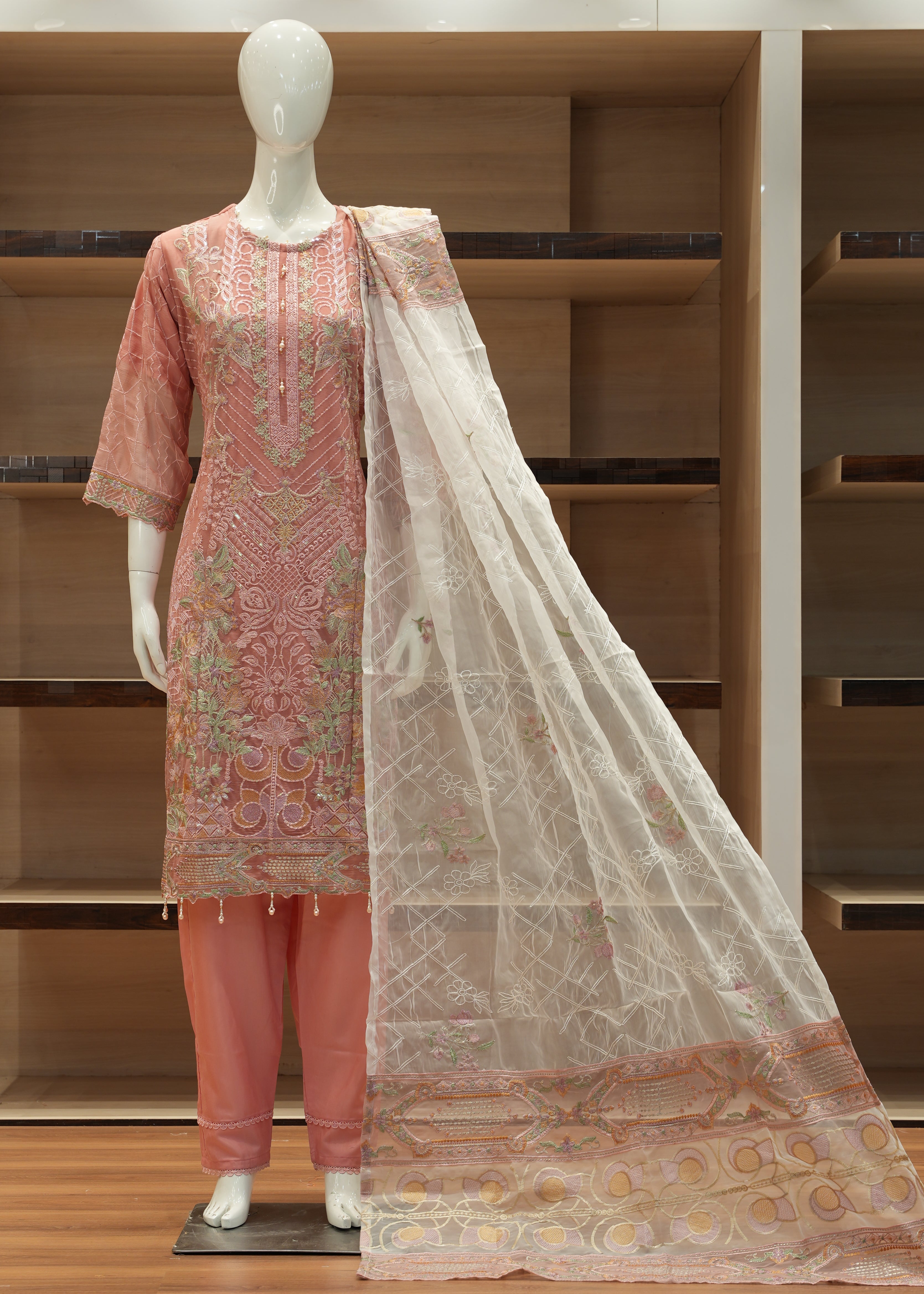 Decorative pink and beige scarf draped over a wooden shelf with a mirror.