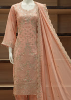 Peach-colored embroidered fabric on a wooden stand