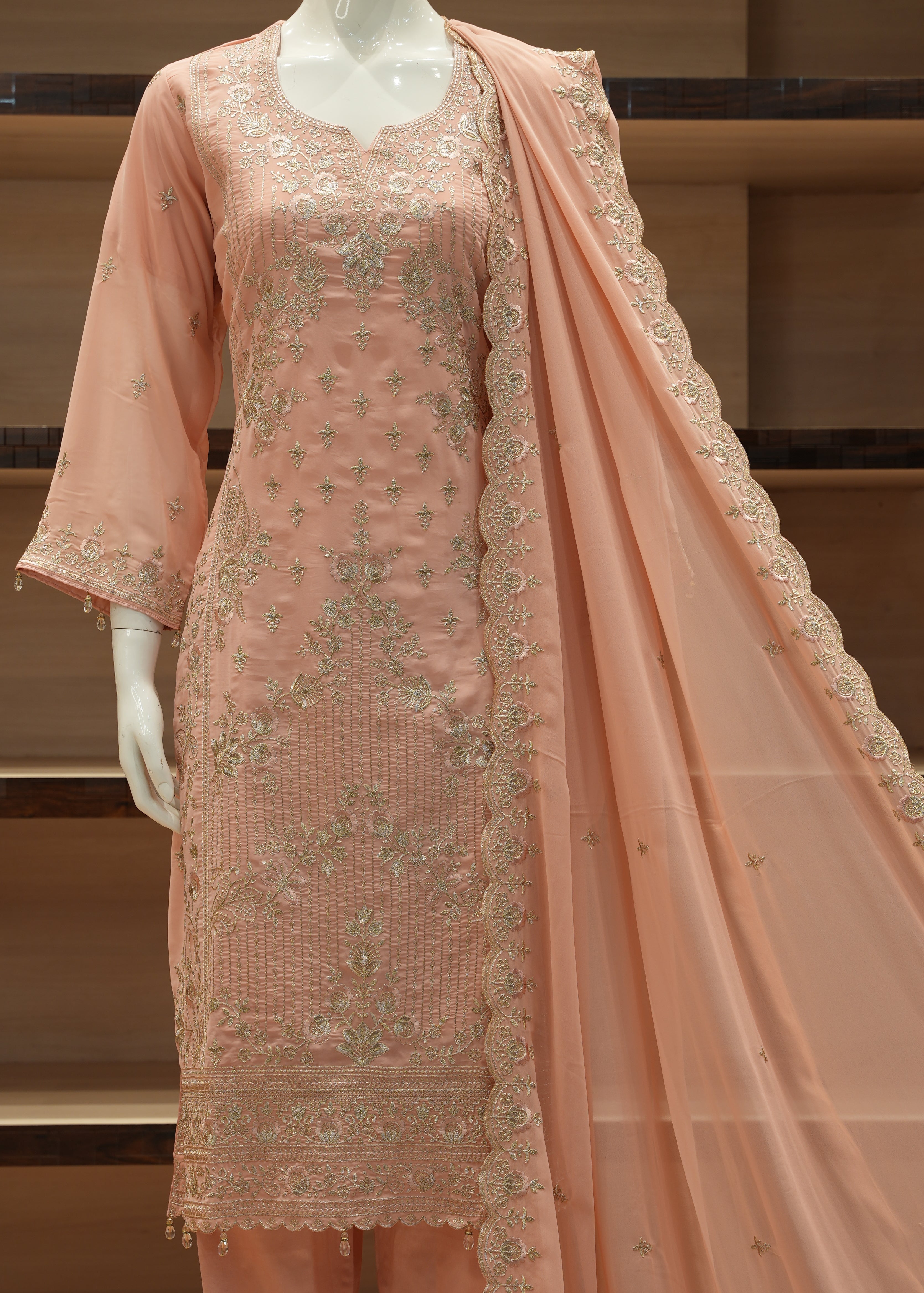 Peach-colored embroidered fabric on a wooden stand