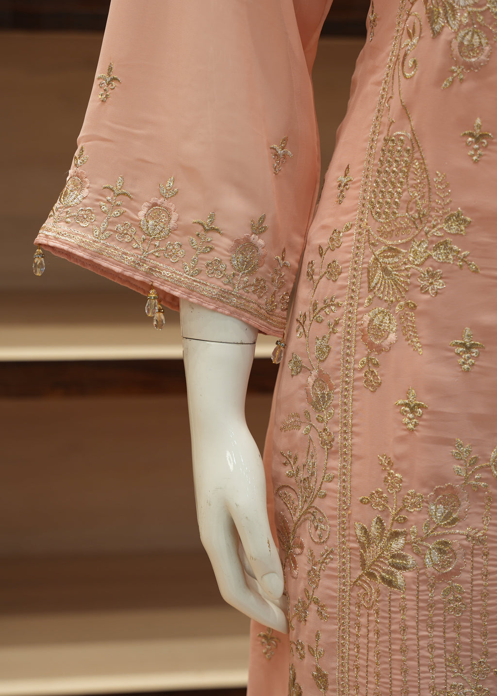 Pink embroidered fabric on a mannequin with a blurred background