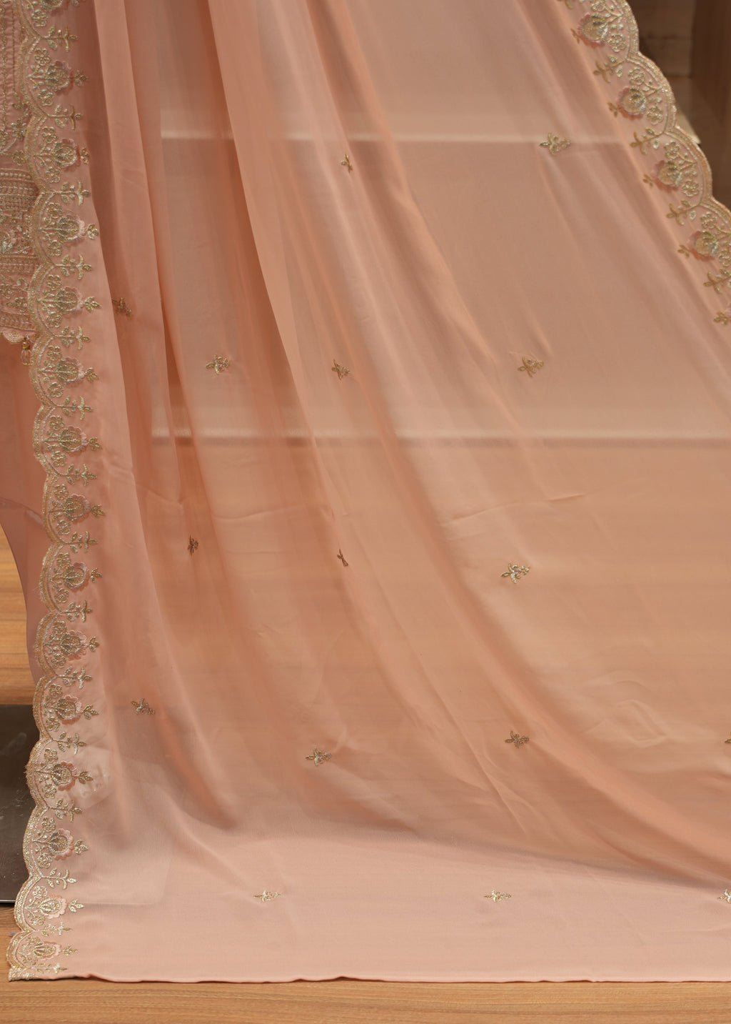 Close-up of a pink embroidered fabric with a wooden background