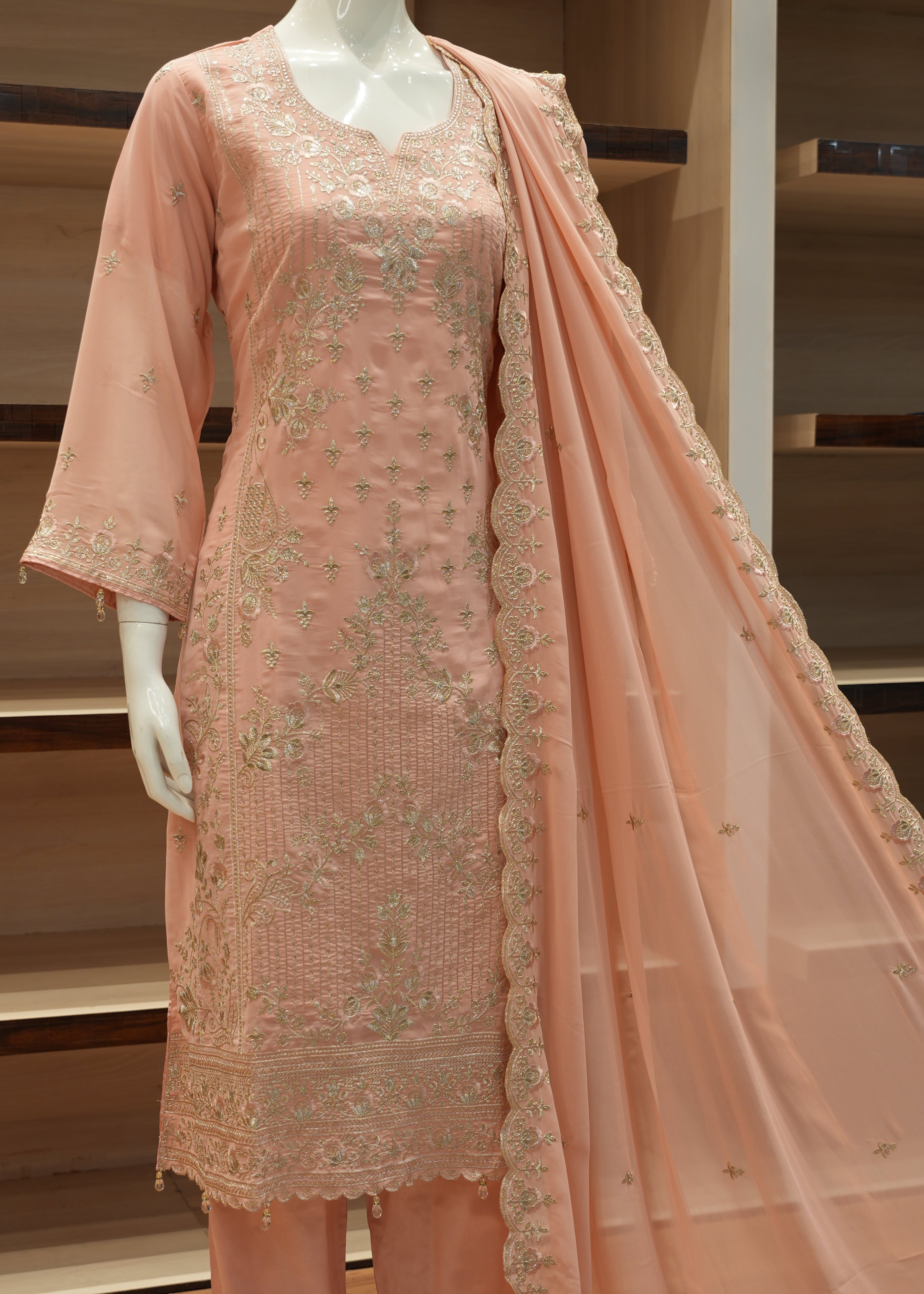 Pink embroidered fabric on a mannequin against a neutral background