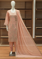 Mannequin wearing a pink embroidered outfit with a matching dupatta against a wooden background