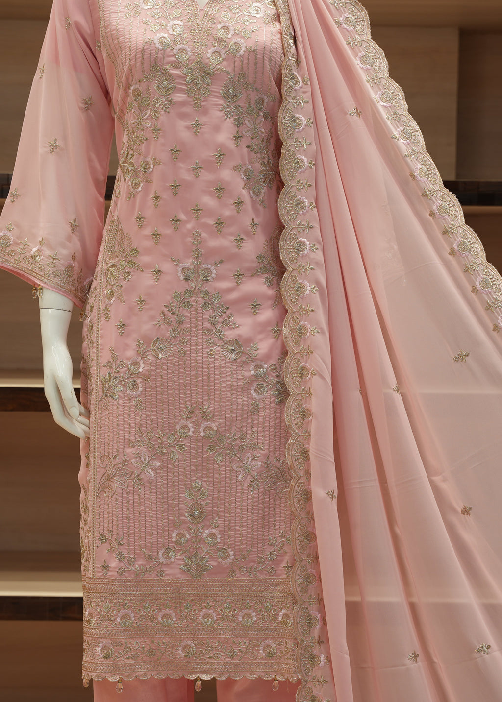 Pink embroidered traditional outfit with a dupatta on a mannequin against a neutral background