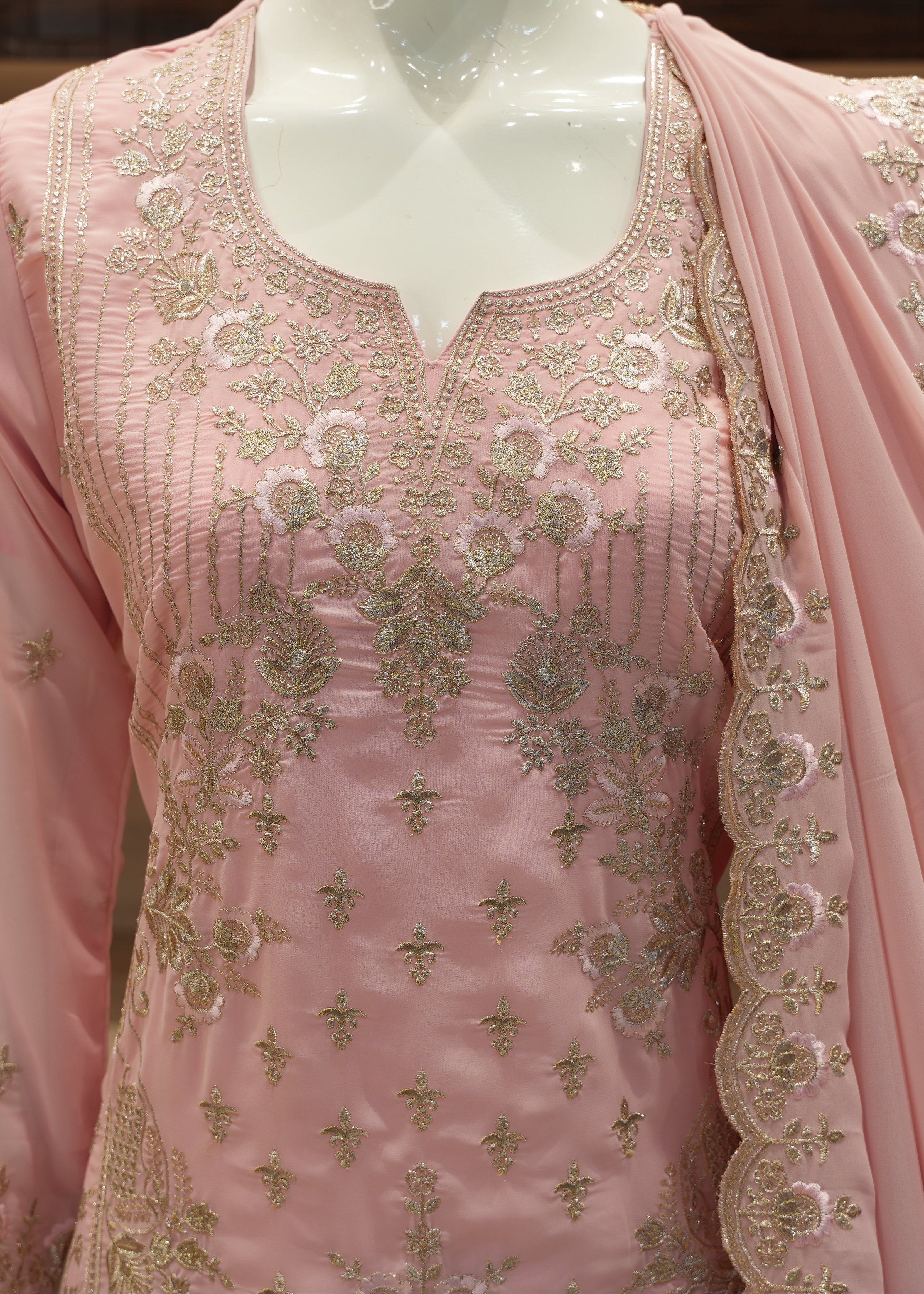 Pink embroidered traditional outfit on a mannequin