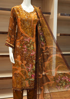 Decorative fabric with floral patterns draped over a wooden surface.